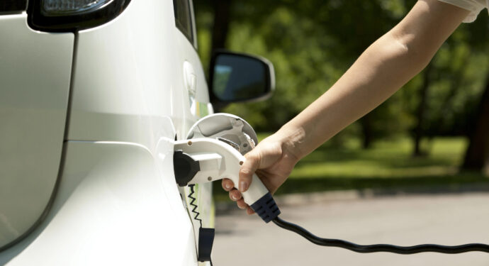 An electric car owner charging their vehicle